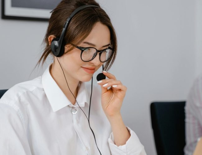 Professional woman using headset for customer service in office setting.